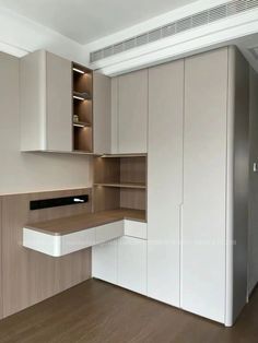 an empty kitchen with white cabinets and wood flooring on the walls, along with a built - in pantry