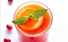 a drink with orange slices and mint garnish