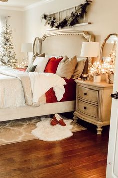 a bedroom decorated for christmas with white and red decorations on the bed, wooden floors