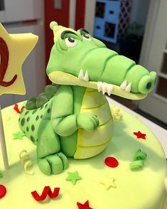 a birthday cake decorated with an alligator and stars