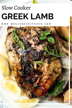 slow cooker greek lamb with lemons and herbs on a white plate next to potatoes