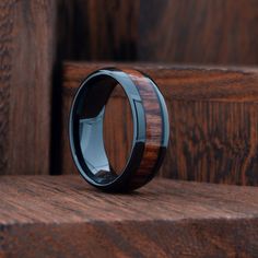 a black ceramic ring with wooden inlays on top of some steps and wood