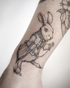 a rabbit tattoo on the arm with a chain around it's neck and legs