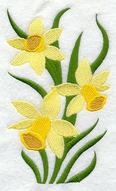 three yellow daffodils with green stems in the center on a white towel