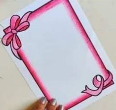 a person holding up a card with a pink bow on it and the word love written in cursive writing