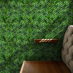 a chair and table in front of a wall with green leaves on it's sides