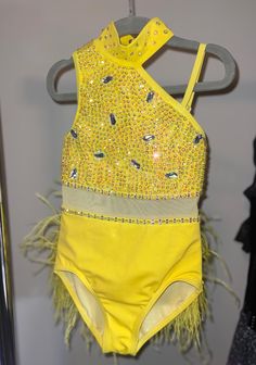 a yellow bathing suit hanging on a rack