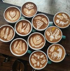 there are many cups that have different designs on them in the shape of animals and leaves