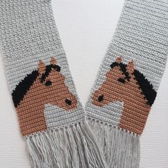 two crocheted scarfs with horses on them, one is brown and the other is gray