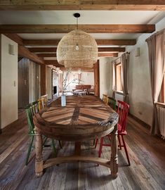 a large wooden table sitting in the middle of a room with lots of chairs around it