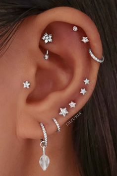 a woman's ear with three different piercings