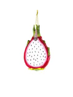 an ornament shaped like a pomegranate hanging from a string on a white background