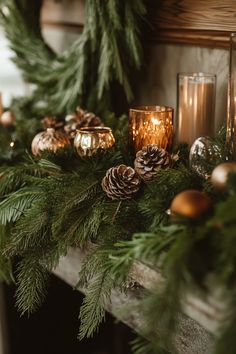 a mantel decorated with pine cones and candles