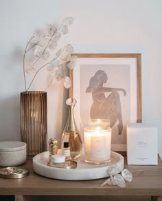 a table with candles, flowers and other items on it in front of a framed photo