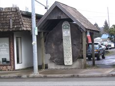 a large tree stump sitting on the side of a road next to a parking lot