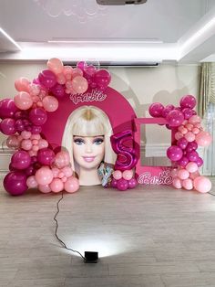 a barbie birthday party with pink balloons and an image of a barbie doll on the wall