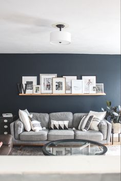 a living room filled with furniture and pictures on the wall