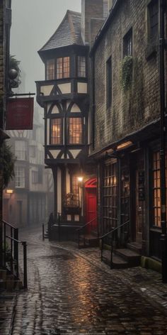 an old fashioned building with a red door in the middle of a cobblestone street