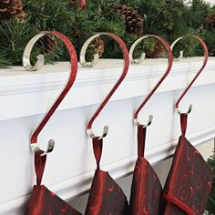 christmas stockings hanging from hooks on a mantel