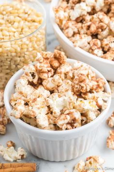 two white bowls filled with popcorn next to cinnamon sticks