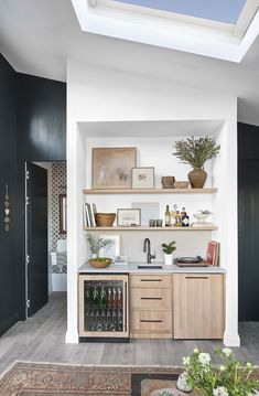 a kitchen with wooden cabinets and shelves filled with bottles, wine glasses and other items