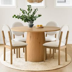 a round table with four chairs around it and a potted plant in the middle