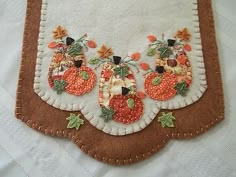 an appliqued piece of cloth with pumpkins and leaves on the border