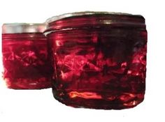 two red jars with lids sitting next to each other