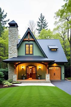 a green house with two garages and a stone chimney in the middle of it