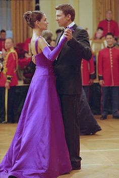 a man and woman in formal dress dancing