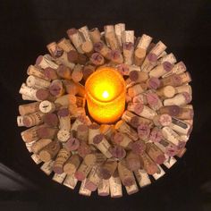 a lit candle surrounded by wine corks