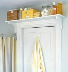 a bathroom with yellow towels hanging on the door and other items sitting on top of it