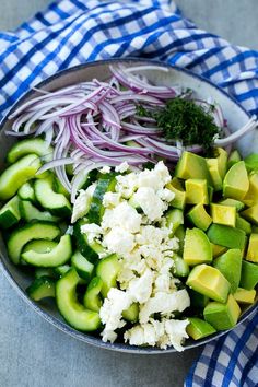 cucumbers, onions and other vegetables are in a bowl