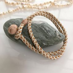 a beaded bracelet sitting on top of a rock