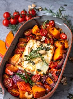 a casserole dish filled with tomatoes, mushrooms and tofu on a table