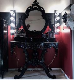 a vanity with a mirror and lights on it in a room that has red walls