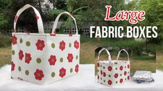 two large fabric boxes sitting on top of a white table covered in flowers and polka dots