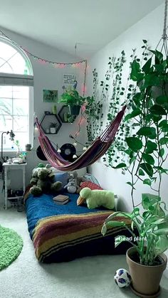 a bedroom with a hammock hanging from the ceiling next to a potted plant