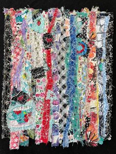 a piece of art made out of various fabrics and threads on a black background