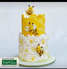 a three tiered cake decorated with bees and daisies