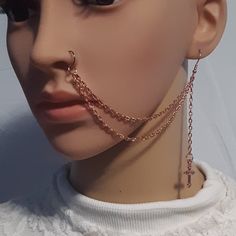 a mannequin head wearing a necklace and nose ring with chains attached to it