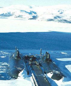 an aerial view of a submarine in the snow with mountains in the backgroud