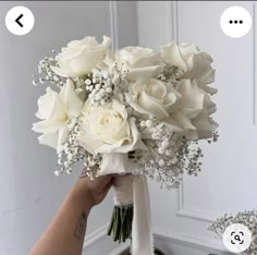 a person holding a bouquet of white flowers