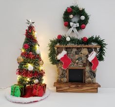 a christmas tree next to a fireplace with stockings on it