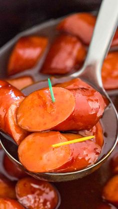 a spoon full of hot dogs with ketchup on them