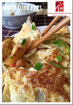 an omelet with chopsticks on top of it sitting on a plate