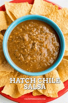 a bowl of salsa with tortilla chips on the side that says hatch chile salsa