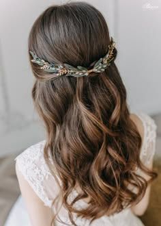 the back of a woman's head with long hair and flowers in her hair