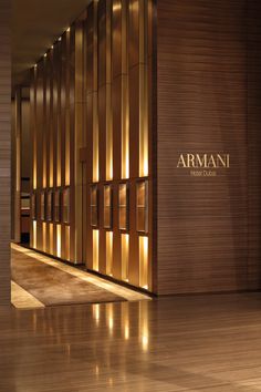 the entrance to an office building with lights shining on it's walls and wood flooring