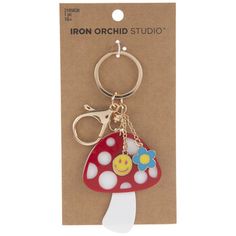 a red mushroom keychain with a smiley face on it's front and bottom